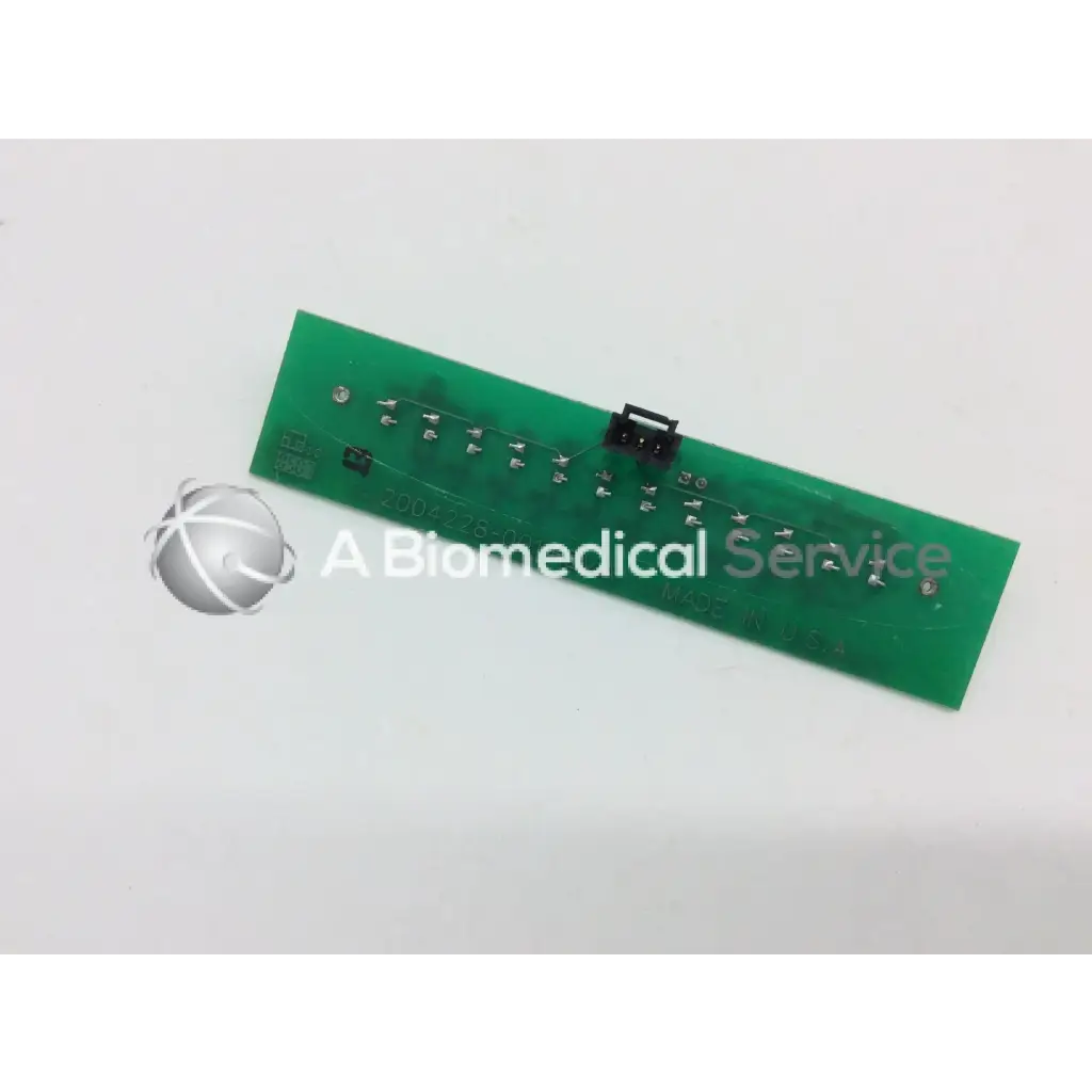 Green rectangular circuit board with silver soldered components and black connector for marquette dash alarm light assembly