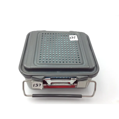 Gray plastic genesis case sterilization container with perforated lid and metal handle for case sterilization