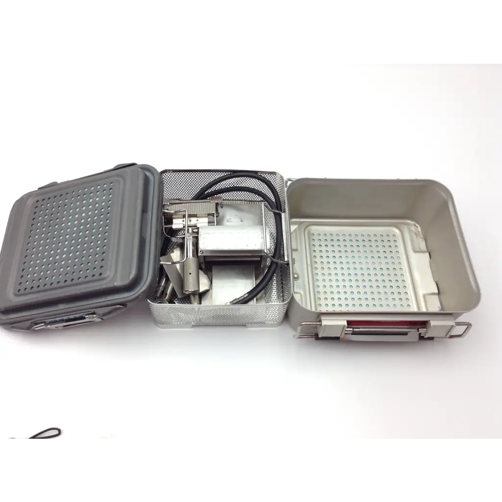 Gray perforated metal genesis case sterilization container with mesh interior and handle for surgical instruments