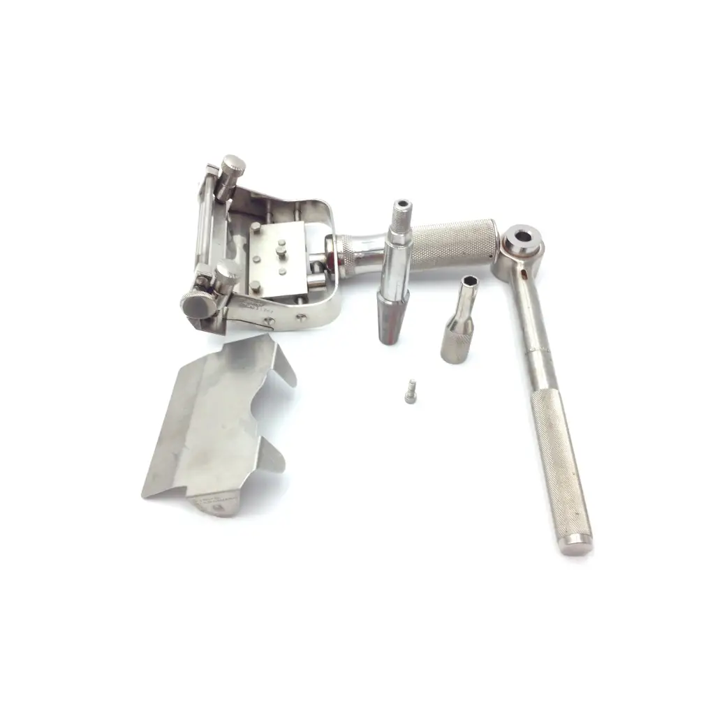 Silver-toned dental handpiece with textured grip and interchangeable attachments in genesis case sterilization container