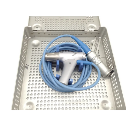 Silver and blue gyrus acmi diego shaver handpiece with coiled tubing resting in perforated metal tray case