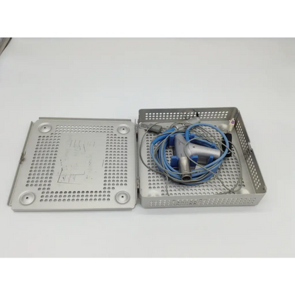 Silver perforated metal surgical tray holding a coiled blue and gray gyrus acmi diego shaver handpiece with case