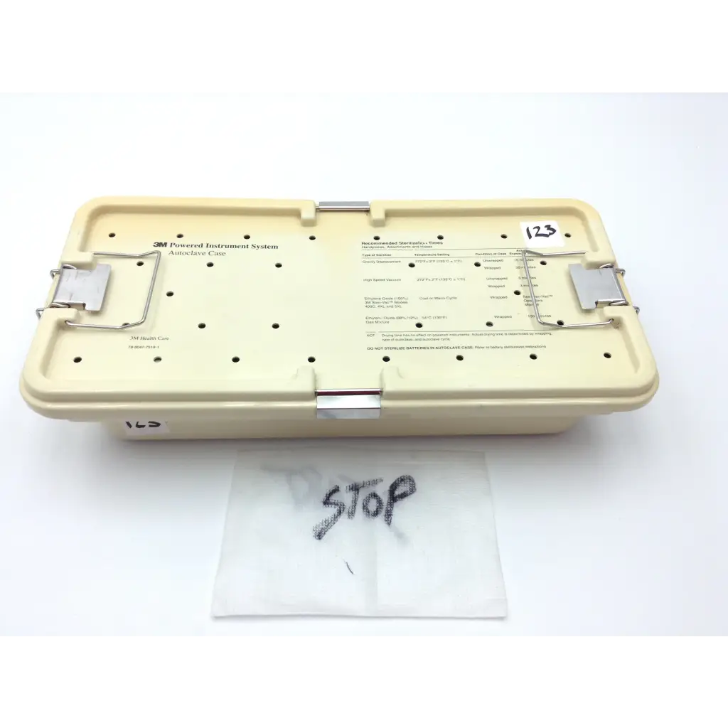 Beige plastic 3m maxi-driver ii autoclave case with metal latches and labeled compartments for surgical instruments