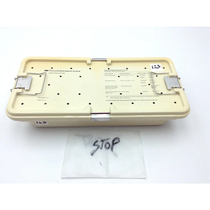 Beige plastic 3m maxi-driver ii autoclave case with metal latches and labeled compartments for surgical instruments