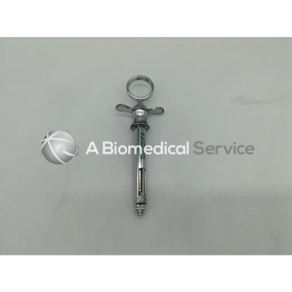 Silver metallic henry schein dental aspirating syringe with ring handle and cross-shaped plunger mechanism