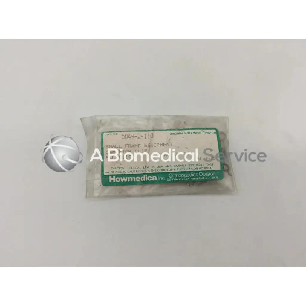A clear plastic bag of small metallic howmedica orthopedic fixation stop clips labeled stop clip 5mm in green and white