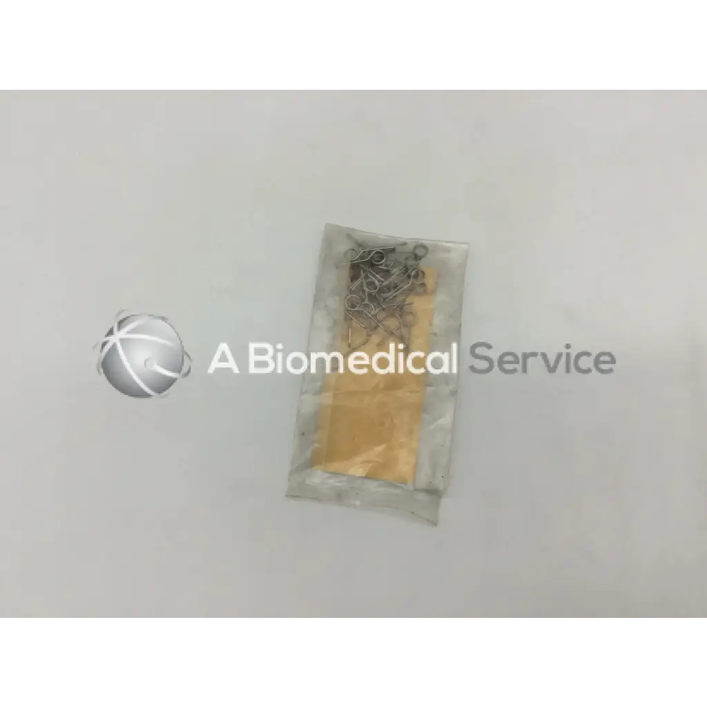 A clear plastic bag containing howmedica orthopedic fixation stop clips 5mm metallic with yellowish components