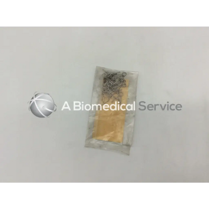 A clear plastic bag containing howmedica orthopedic fixation stop clips 5mm metallic with yellowish components