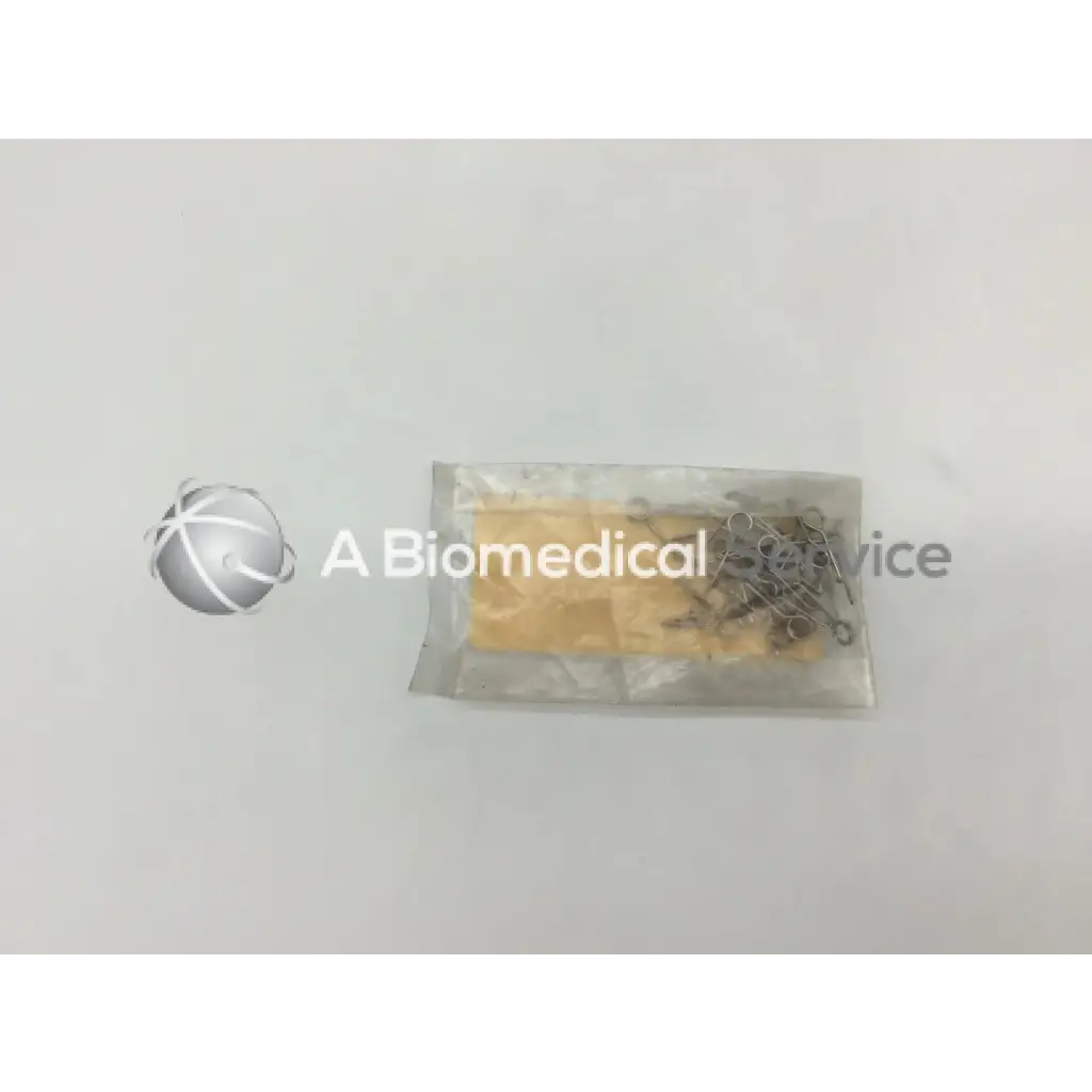 A clear plastic bag containing a yellow orthopedic fixation stop sponge and metallic howmedica fixation stop clip 5mm