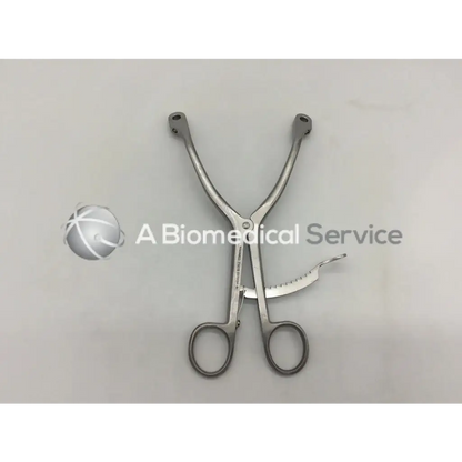 Silver innomed t1015 kolbel surgical instrument with curved handles and serrated cutting blade for precise surgery