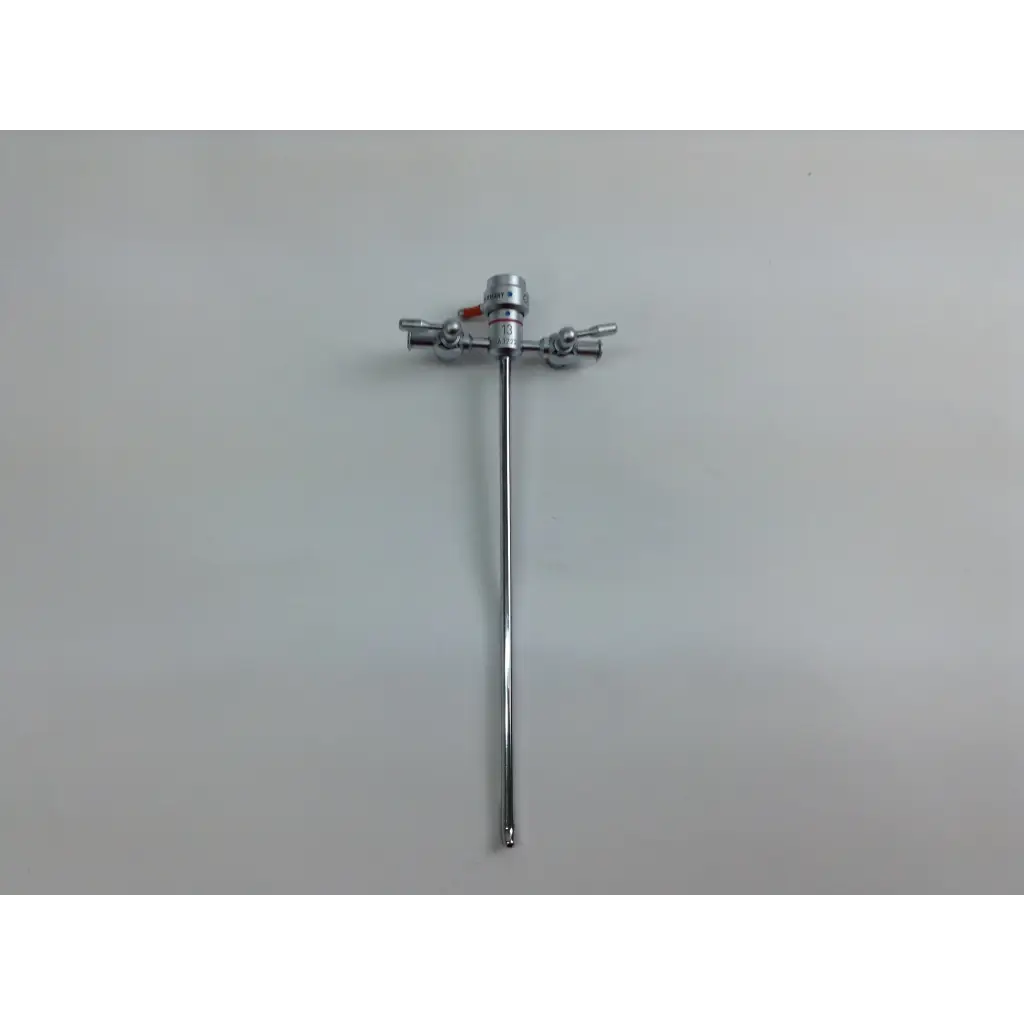 Shiny chrome olympus cystoscopy resection set with long slender shaft and three perpendicular handles in aesculap sterilization case