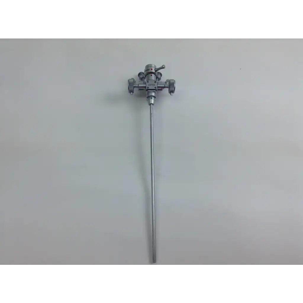 Silver surgical instrument with slender shaft and complex head from olympus cystoscopy resection set in aesculap sterilization case