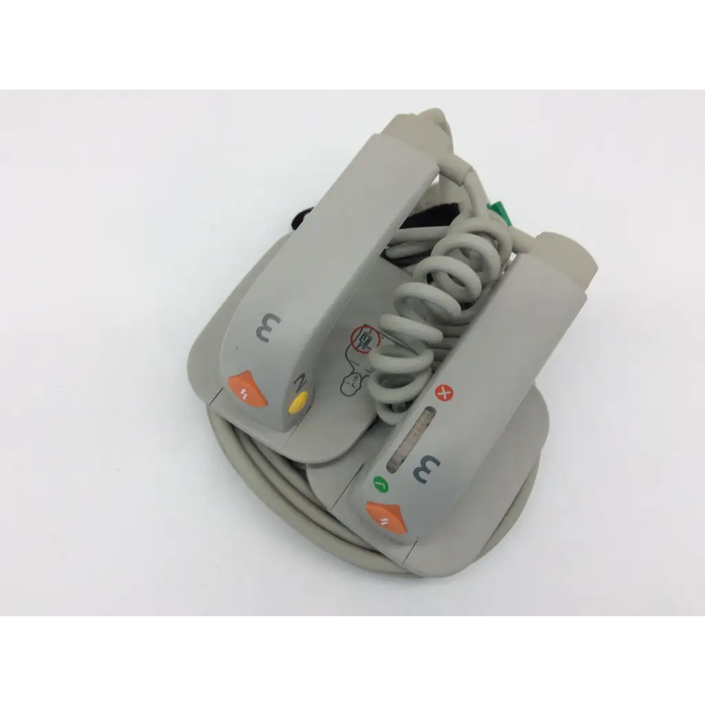 Gray philips external hard paddles defibrillator m3543a with coiled cable and colored indicator buttons