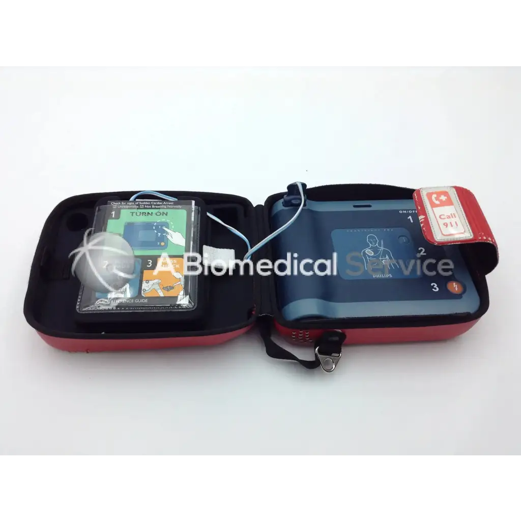 Red and black portable philips heartstart frx aed trainer case with defibrillator and instructional guide for emergency use