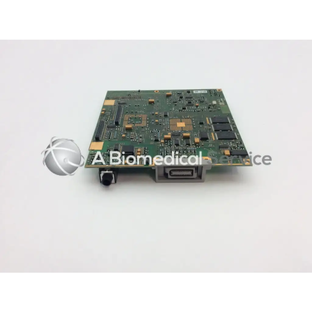 Green rectangular patient monitor circuit board with black and gold components and silver connector port on right side