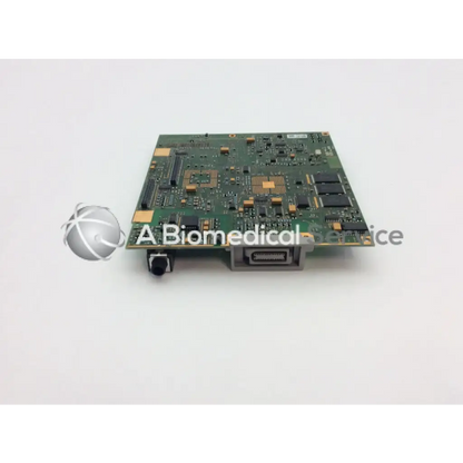 Green rectangular patient monitor circuit board with black and gold components and silver connector port on right side