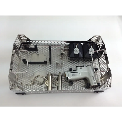 Silver metallic surgical instrument tray with perforated design holding dental tools in aesculap case for cordless driver set