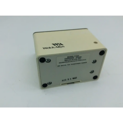 Beige welch allyn charging stand 71123 with black screw caps and printed labeling for welch allyn charging use