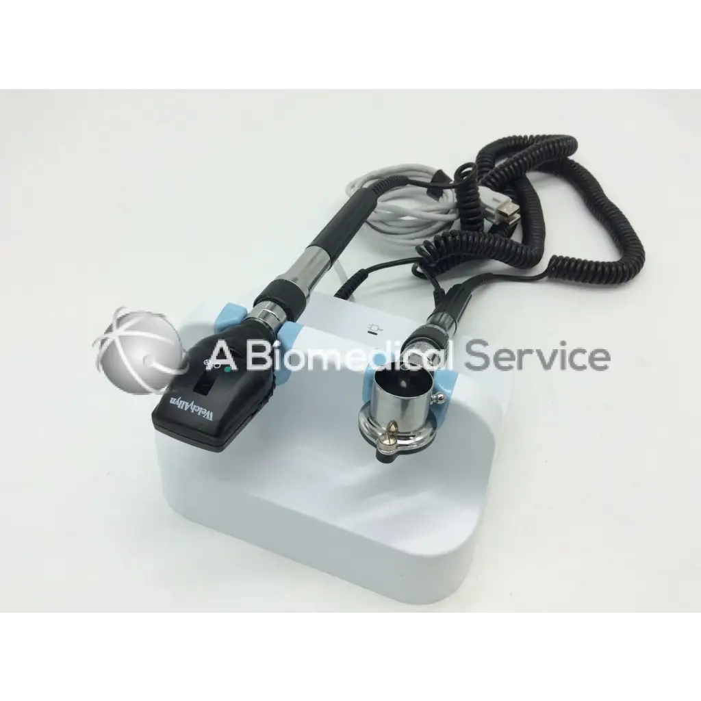 Black and silver handheld welch allyn green series wall transformer ophthalmoscope with coiled cables on white base