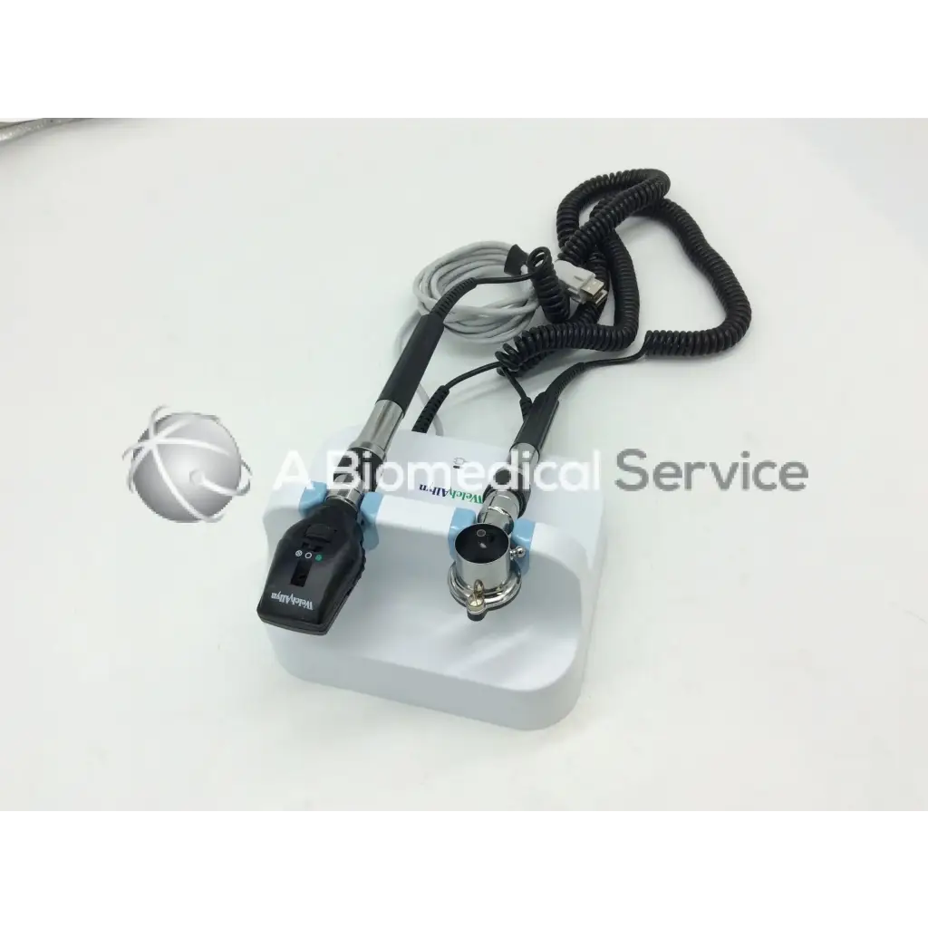 White plastic base holding a black and silver handheld welch allyn green series wall transformer ophthalmoscope with coiled cables