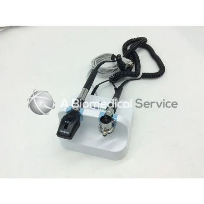 White plastic base holding a black and silver handheld welch allyn green series wall transformer ophthalmoscope with coiled cables
