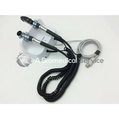 Black and silver dual-ended medical endoscope with coiled cables on white base for welch allyn green wall transformer opthalmoscope