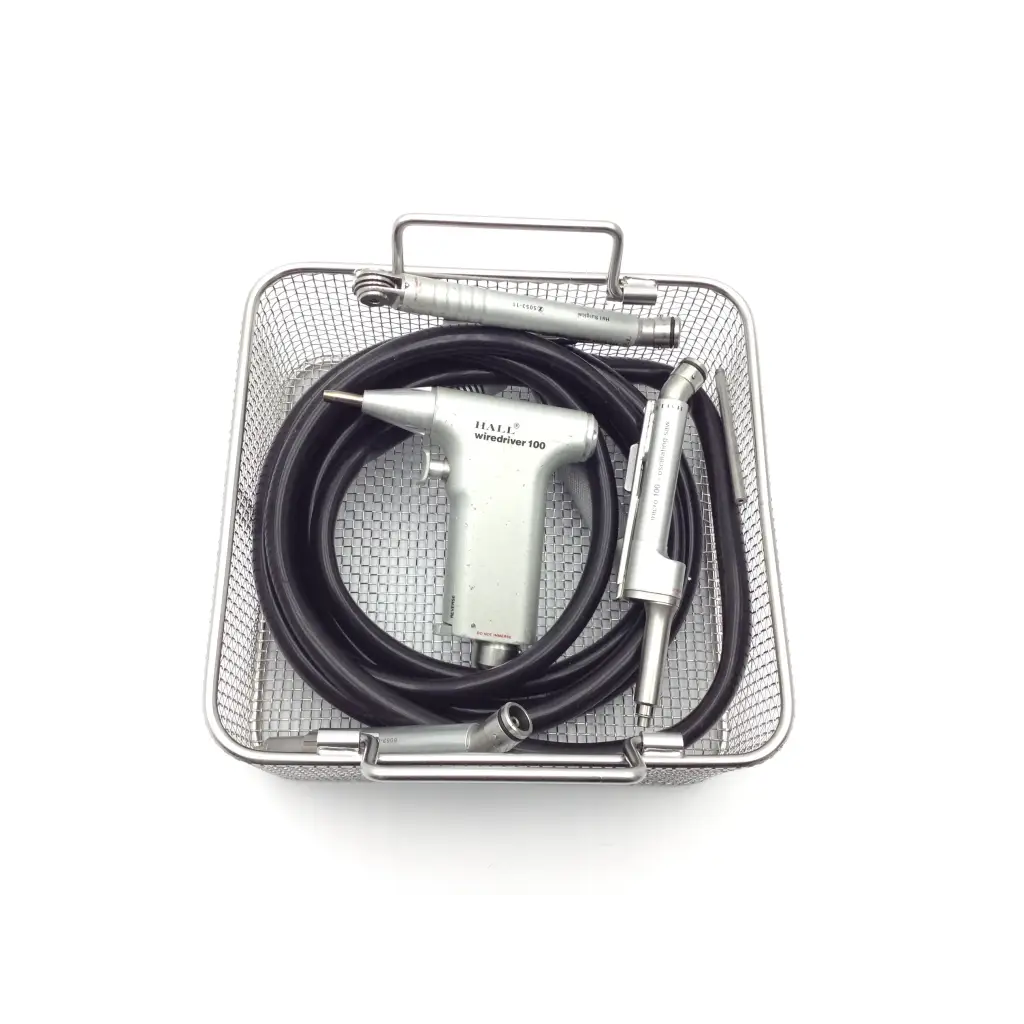 Silver hall wiredriver 100 dental handpiece with black pneumatic hose orthopedic driver and metallic attachments in mesh basket